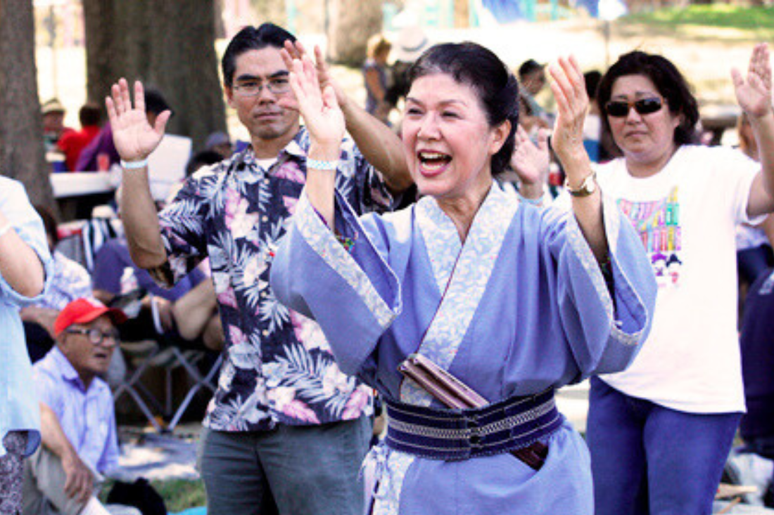 Individuals dancing during obon ondo at picnic
